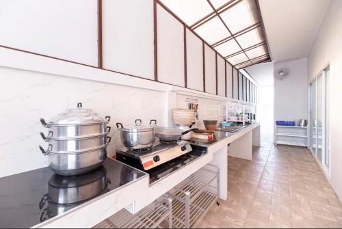 a kitchen with a counter with pots and pans at 91 Smile Pool Villa Sattahip in Ban Tao Than