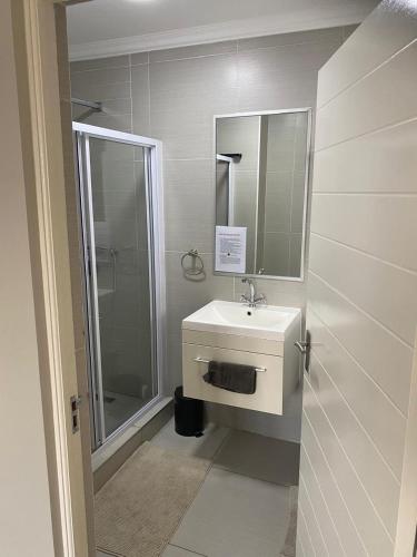 Un baño con lavabo, ducha y espejo. en The Falls Lifestyle Estate, en Roodepoort