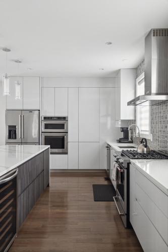 a kitchen with white cabinets and stainless steel appliances at Luxury 4BR home 7 mins to US Capital, Rooftop deck, in Washington Free Parking in Washington, D.C.