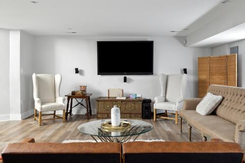 a living room with a couch and a tv on a wall at Luxury 4BR home 7 mins to US Capital, Rooftop deck, in Washington Free Parking in Washington, D.C.