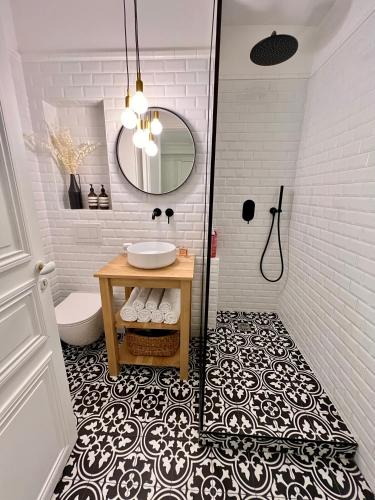 une salle de bain avec un lavabo et un miroir dans l'établissement Appartement de charme - Place Victor Hugo - Paris 16e, à Paris