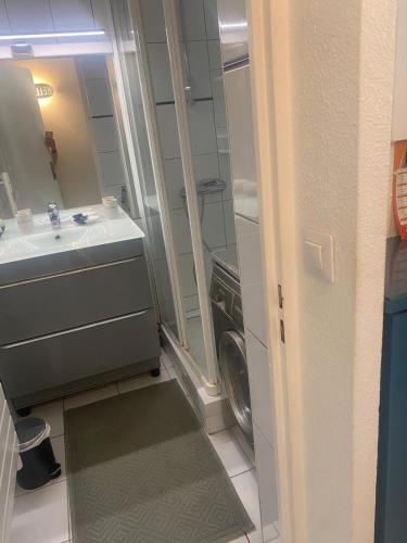 une salle de bain avec un lavabo et une machine à laver dans l'établissement Appartement vue mer, à Sète
