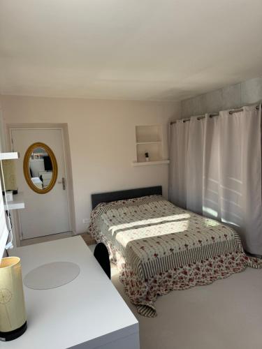 une petite chambre avec un lit et un miroir dans l'établissement Coin de bien-être à Ronchamp, à Ronchamp