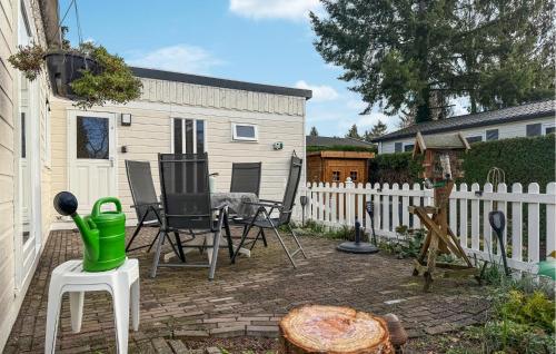a patio with a table and chairs and a fence at Nice Chalet In Putten in Putten