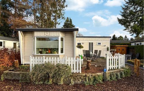 a small house with a white picket fence at Nice Chalet In Putten in Putten