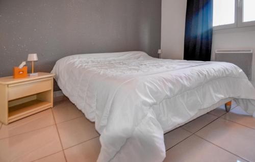 une chambre avec un lit blanc et une table de chevet dans l'établissement 1 Bedroom Amazing Home In Mas-Thibert, à Mas-Thibert