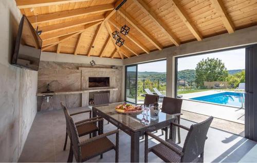 a dining room with a table and chairs and a pool at Stunning Home In Trilj With Wifi in Trilj