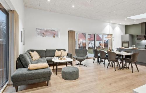 a living room with a couch and a table and chairs at 4 Bedroom Nice Home In Hadsund in Hadsund