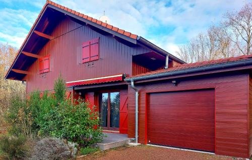 a red house with two garage doors in front at Lovely Home In Langatte With Wifi in Langatte