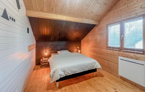 a bedroom with a bed in a room with wooden walls at Lovely Home In Langatte With Wifi in Langatte
