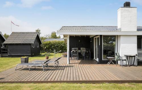 a deck with a table and chairs on a house at 3 Bedroom Lovely Home In Otterup in Otterup