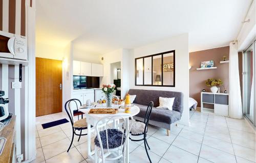 une cuisine et un salon avec une table et un canapé dans l'établissement Pet Friendly Apartment, à Saint-Georges-de-Didonne