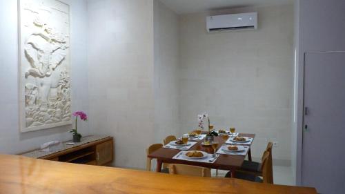 a dining room with a table with plates of food at De Luxe Villa Fabian Escape in Seminyak in Seminyak