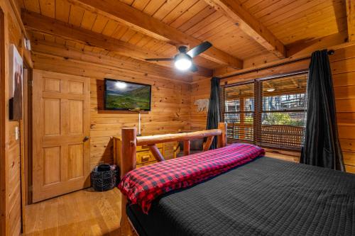 Un dormitorio con una cama en una cabaña de madera. en Bearolina On My Mind, en Pigeon Forge
