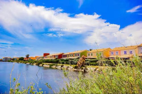 a train on a track next to a river at Belle marina en bord d'étang in Le Barcarès
