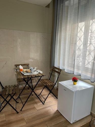 a kitchen with a table and chairs and a refrigerator at B&B Son De Mar in Salerno