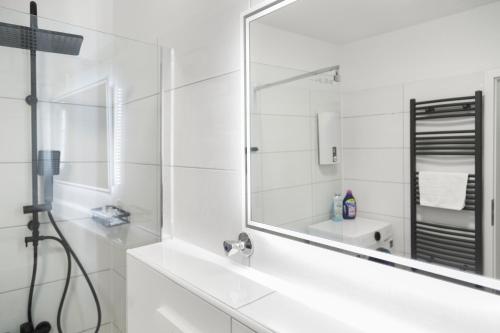 a white bathroom with a mirror and a sink at VlNFUL2 Premium-Apartment mit Balkon und Parkplatz in Mülheim an der Ruhr