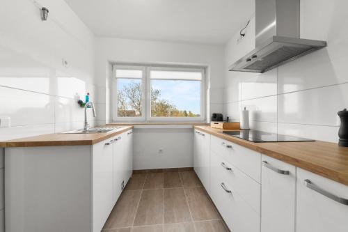 a white kitchen with a sink and a window at VlNFUL2 Premium-Apartment mit Balkon und Parkplatz in Mülheim an der Ruhr