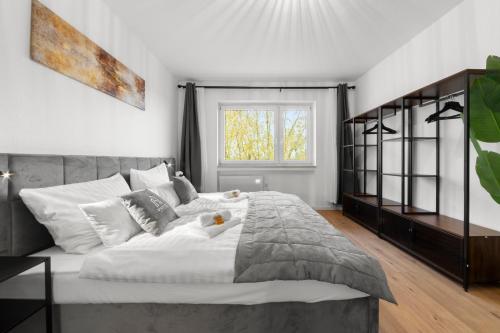a bedroom with a large white bed and a window at VlNFUL2 Premium-Apartment mit Balkon und Parkplatz in Mülheim an der Ruhr