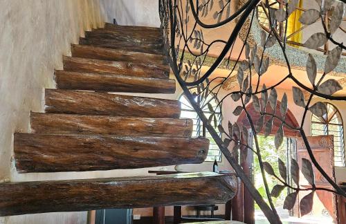 a wooden staircase in a room with a stained glass window at Eagle Suite 38m2 in Villa 560 m2, Indian Ocean View in Shimoni