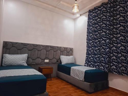 a bedroom with two twin beds and a couch at Appartement Ghita Essaouira in Essaouira