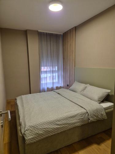 a bedroom with a bed and a window at Sajam 2 in Novi Sad