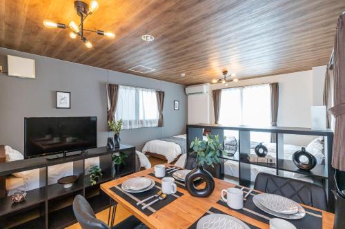a living room with a dining table and a room with a bed at セントラルフィールド in Tokyo