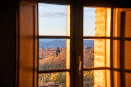 a window with a view of autumn trees through it at San Carlo a La Molinella in Città della Pieve