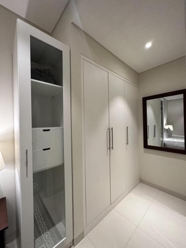 a room with white cabinets and a mirror at Hawana Salalah luxury 1BR TH with private pool in Ma‘mūrah