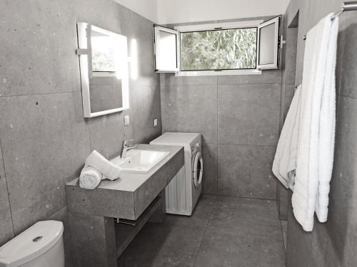 a bathroom with a sink and a toilet and a window at SPITAKI in Pefkohori