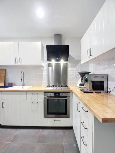 une cuisine avec des armoires blanches et un four à plaques de cuisson dans l'établissement Maison Avignon intra-muros, à Avignon