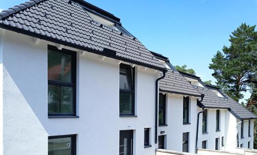 a row of white houses with black windows at Villa HM am Waldrand in Mödling