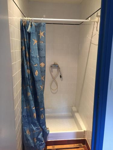 une douche avec un rideau de douche bleu dans une salle de bain dans l'établissement Maison à Belle Ile en mer, au Palais
