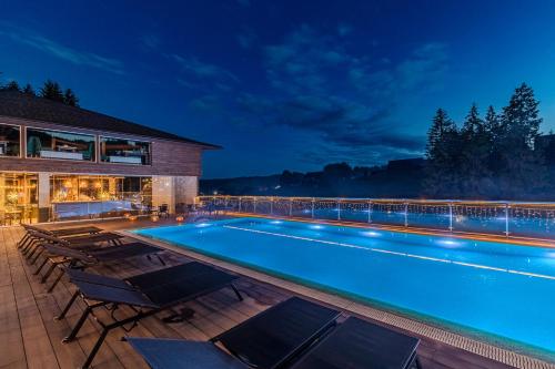 a swimming pool with chairs and a house at SPA HOTEL Gora in Bukovel