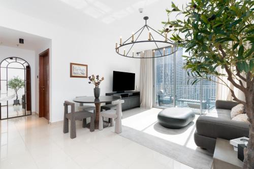 a living room with a table and a tv at Downtown,Fountain view, nearBurj Khalifa,3 minutes walk to Dubai Mall in Dubai