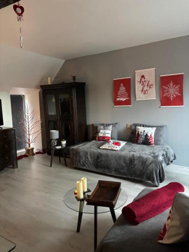 a living room with a bed and a couch at Gite le Patis in Pré-en-Pail