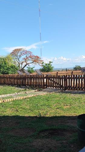 a wooden fence with a tree in the background at Pousada o Canto da Seriema in Nobres