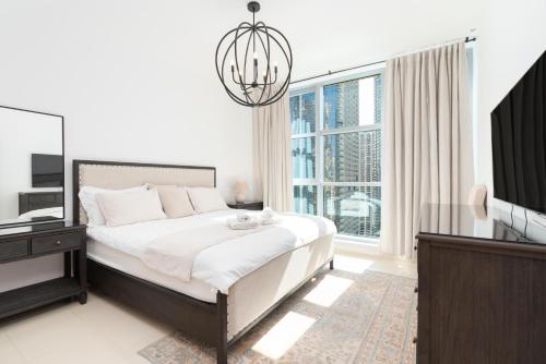 a bedroom with a bed and a television and a chandelier at Downtown,Fountain view, nearBurj Khalifa,3 minutes walk to Dubai Mall in Dubai