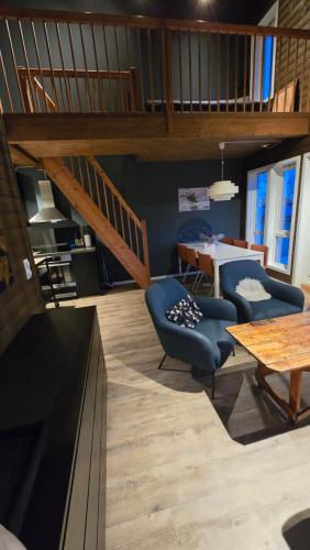 a living room with a staircase and a table and chairs at Hemmingodden Lodge in Ballstad