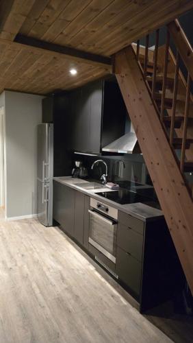a kitchen with a wooden staircase in a room at Hemmingodden Lodge in Ballstad