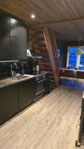 a kitchen with a sink and a staircase in a room at Hemmingodden Lodge in Ballstad