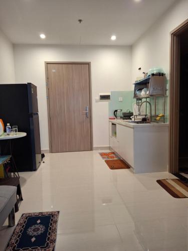 a kitchen with a refrigerator and a table and a door at Vinhomes Grand Park in Long Bình