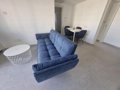a blue couch in a living room with a table at Boutique Nesher in Nesher