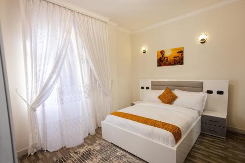 Un dormitorio con una cama blanca y una ventana. en Amnen Apartments, en Addis Ababa