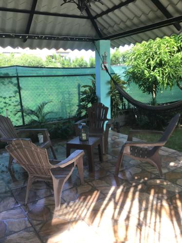 a patio with chairs and a hammock and water at Villa Nilsa ( The Blue House ) in Baní