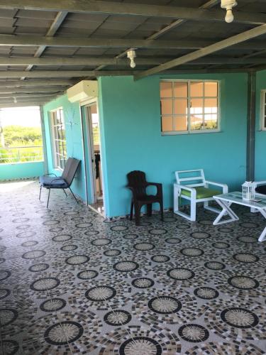 a room with chairs and a blue wall at Villa Nilsa ( The Blue House ) in Baní