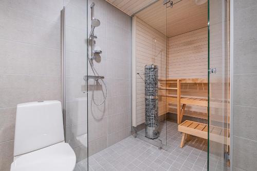 a bathroom with a shower and a toilet at Compact 2BDR Apartment with Private Sauna in Rovaniemi