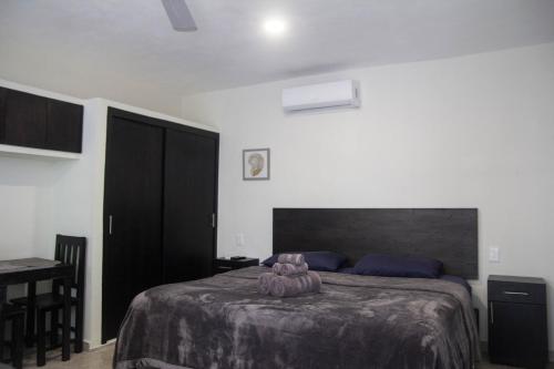 a bedroom with a bed and a table with a chair at Casa Creunza de Mar in Playa del Carmen