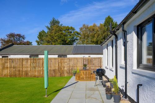 a backyard of a house with a fence at Almara- Cosy cottage in fife in Fife