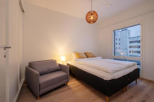 a bedroom with a bed and a chair in it at Compact 2BDR Apartment with Private Sauna in Rovaniemi